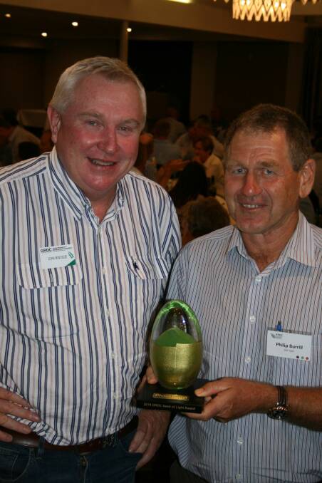 Grains Research and Development Corporation (GRDC) Northern Panel chair John Minogue presents the 2018 Northern Seed of Light award to widely respected senior development agronomist with the Queensland Department of Agriculture and Fisheries (DAF) Philip Burrill. Photo: supplied

