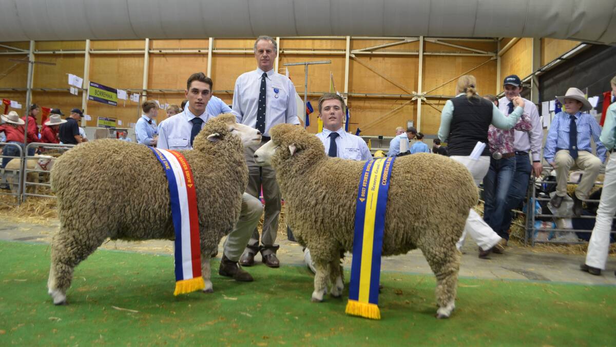 Judge, Charlie Prell with the grand and reserve grand champion Corriedale ewes paraded by St Gregory's College students, Izac Kaluzyn and Michael Watkins.