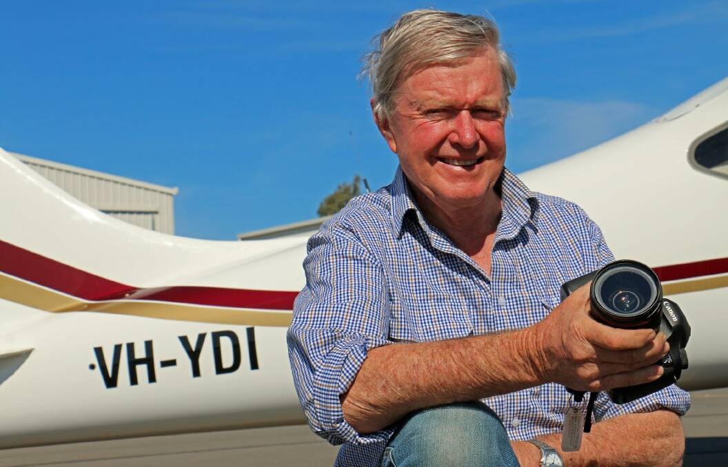 Photographs from the air: David Taylor with his camera and aeroplane preparing for another aerial shoot across Lake Eyre. Photo: supplied. 