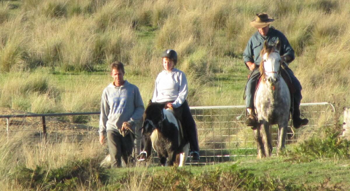 Therapy: Danny Farrell and his father William, leading Meg on her favorite pony Chloe, around the family farm near Bombala. Photo: Kath Farrell.