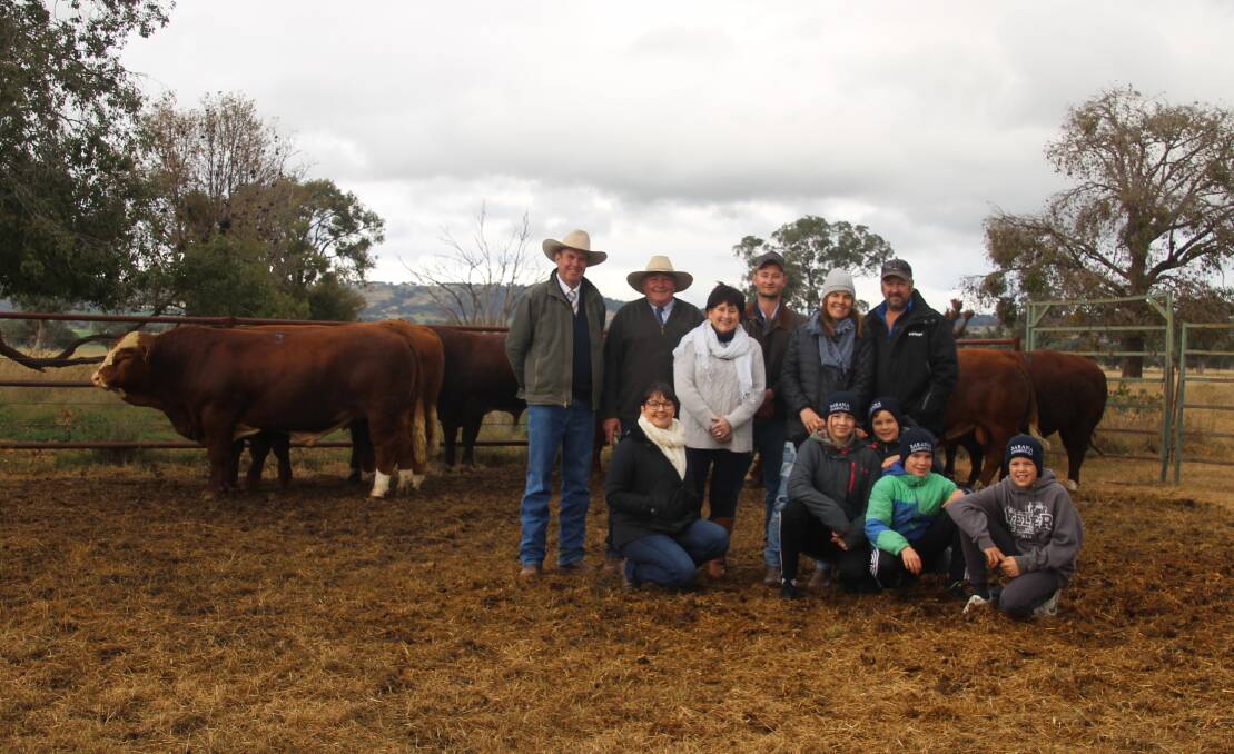 Volume buyers the Sinclair family with the Cook family and auctioneer Paul Dooley (far left). They are pictured with some of the draft of seven bulls that the Sinclair family will take back to Victoria.