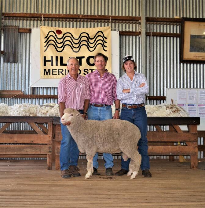 Adam Mort, co-principal Hilltop Merinos, holding the second top priced ram with purchaser Richard and Angus McIntosh from McIntosh Pastoral, Molong, who were also one of the volume buyers taking home six rams.