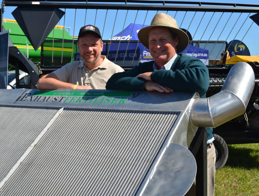  German visitor to Commonwealth Bank AgQuip, Joe Herfort, from Agrotop, Munich, talks with Stubble Cruncher principal, Colin Harper “Taravale”, Ariah Park, about his tractor roof mounted Exhaust Fertiliser converter developed with aircraft engineer David Finch.