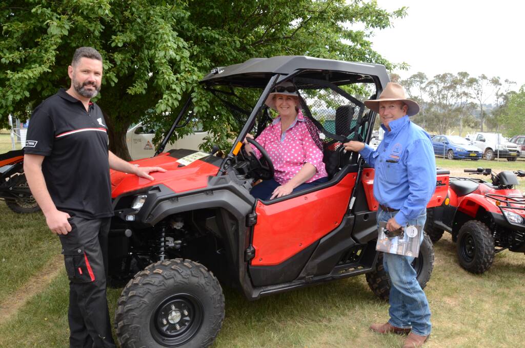 Cameron Beard shows a Honda SXS1000 side-by-side, to Megan and Andrew Mosely, Etiwanda Station, Cobar, at the ANFD. Photo: Rachael Webb