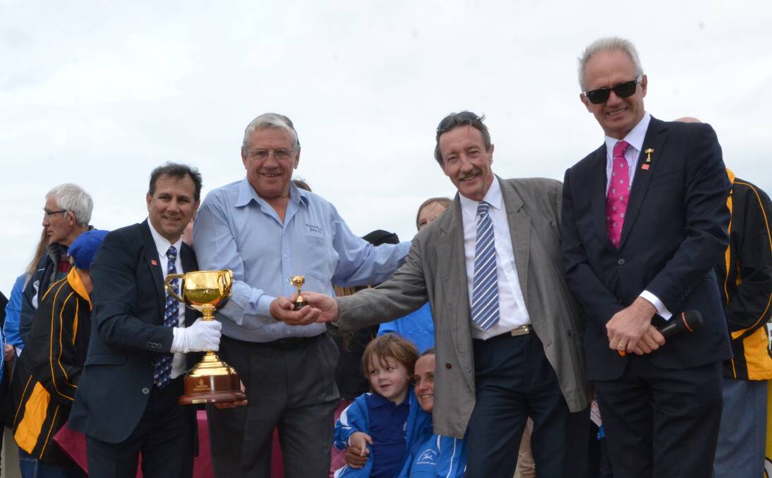 Cup-winning jockey John Marshall holding the Emirates Melbourne Cup trophy with Tuncurry Forster Jockey Club president Garry McQuillan; Andrew Farr, Great Lakes FM radio station; and Joe McGrath, Victoria Racing Club. 