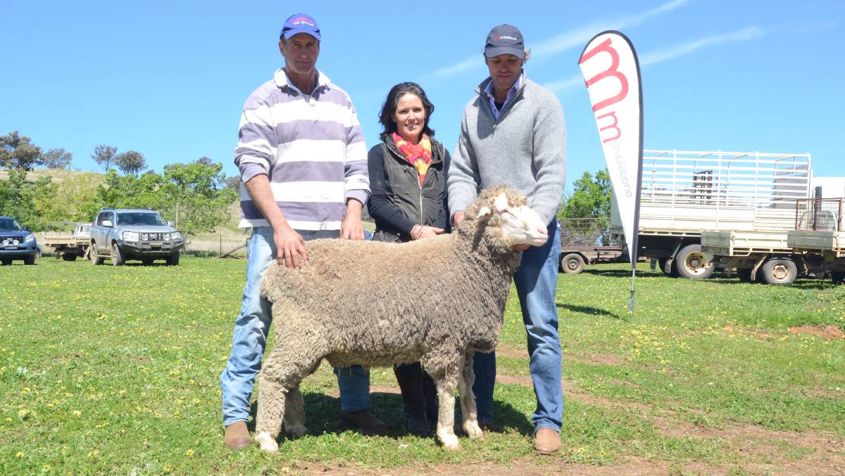 Returning to buy two rams Jim McLaughlin, Merryabone North stud, Warren, paid $5000 for this third-top priced ram and is pictured with Louise and Chad Taylor.