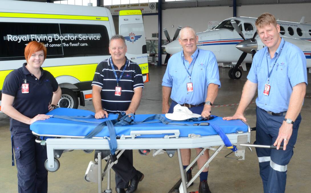 Royal Flying Doctor Service - South East's Dubbo operations coordinator, Kendall Graham with a modern Bariatric special purpose stretcher with Dubbo base manager, Darren Schiller; driver, Bob Browne and pilot Otto Peeters.