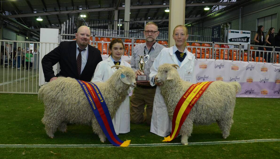 Schools champion. The judge Fred L Speck Junior, Speck Angoras, Kerrville, Texas, USA, with champion schools Angora exhibit, Willow Glen Rahmosteffi, shown by Willow Glen Angoras, West Wyalong; with Phillip Oliver, Secretary, Eastern Branch, Mohair Australia presenting trophy. Reserve champion Willow Glen Kirrishanrivkee, held by Molly Cattle, West Wyalong High School.