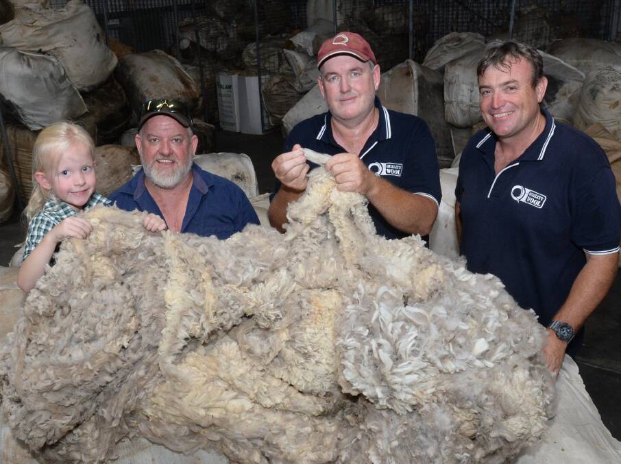 Five year-old Connie Fryer and her dad, Steve, "The Bungalow", Gunningbland, among many donated fleeces at Quality Wool, Parkes, with Chris Scott and Anthony Windus.