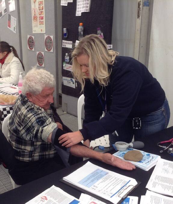 Royal Flying Doctor Service mental health nurse Vanessa Latham checks a man's blood pressure at the Brewarrina show last year. 