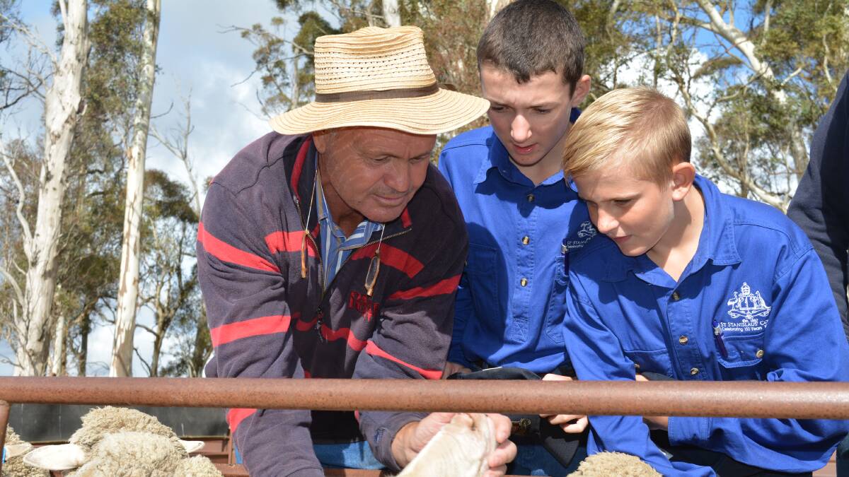 George Merriman, Merryville stud, Boorowa, giving some tops to St Stannies students Malcolm Barlett and Paddy Lowe. 