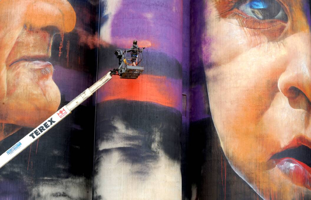 Artist Adnate paints the Sheep Hills silos. Photo: Olivia Page