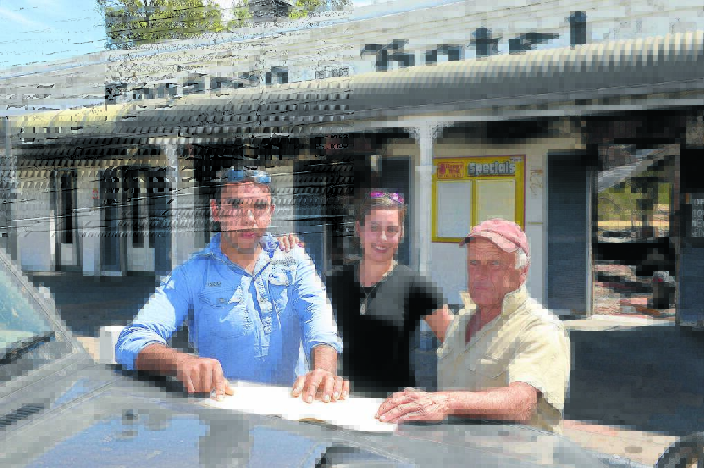 Conargo Pub owner, Charlie White, and his partner Sacha Bond, with retired village resident Trevor Hussey, look over Charlie's plans for the rebuilding of the hotel.