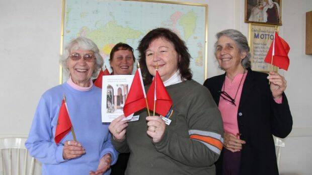 Marion Collier, in the middle holding two flags, in happier times at a CWA fundraiser at Wellington, NSW, in 2013. Photo: The Wellington Times