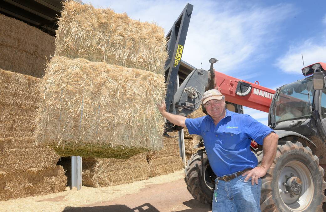 Ross Simpson, Binginbar Farms, Gollan with hay they travelled down south to cut this year to save costs. Photo: Rachael Webb