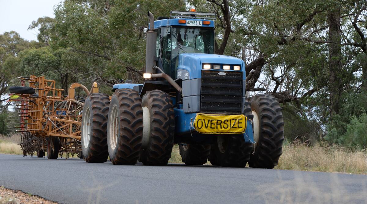 A tractor towing farm machinery near Trangie. Farmers are still waiting for a system that doesn't cause long permit delays.