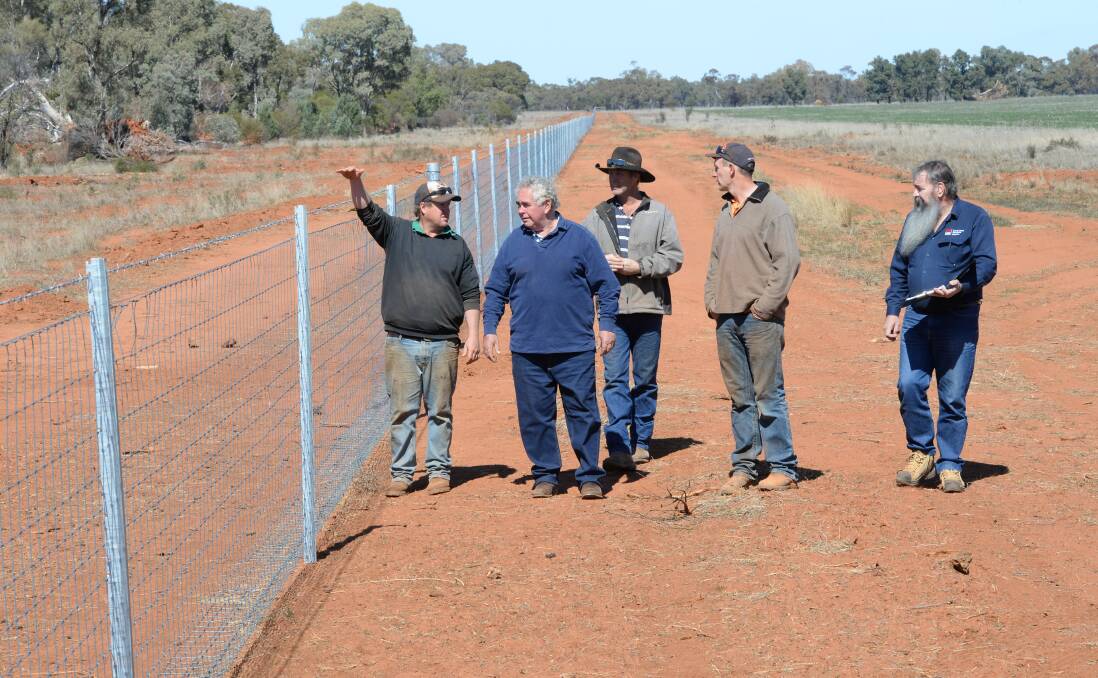 The Gilgunnia fence with landowners and LLS officer Brian Dohnt.