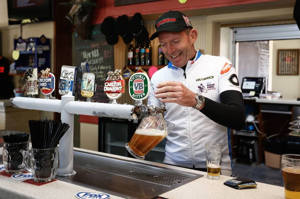 Tony Abbott gets busy behind the taps at Adaminaby's Snow Goose hotel during the Pollie Pedal tour. Pictures of Mr Abbott by Alex Ellinghausen.