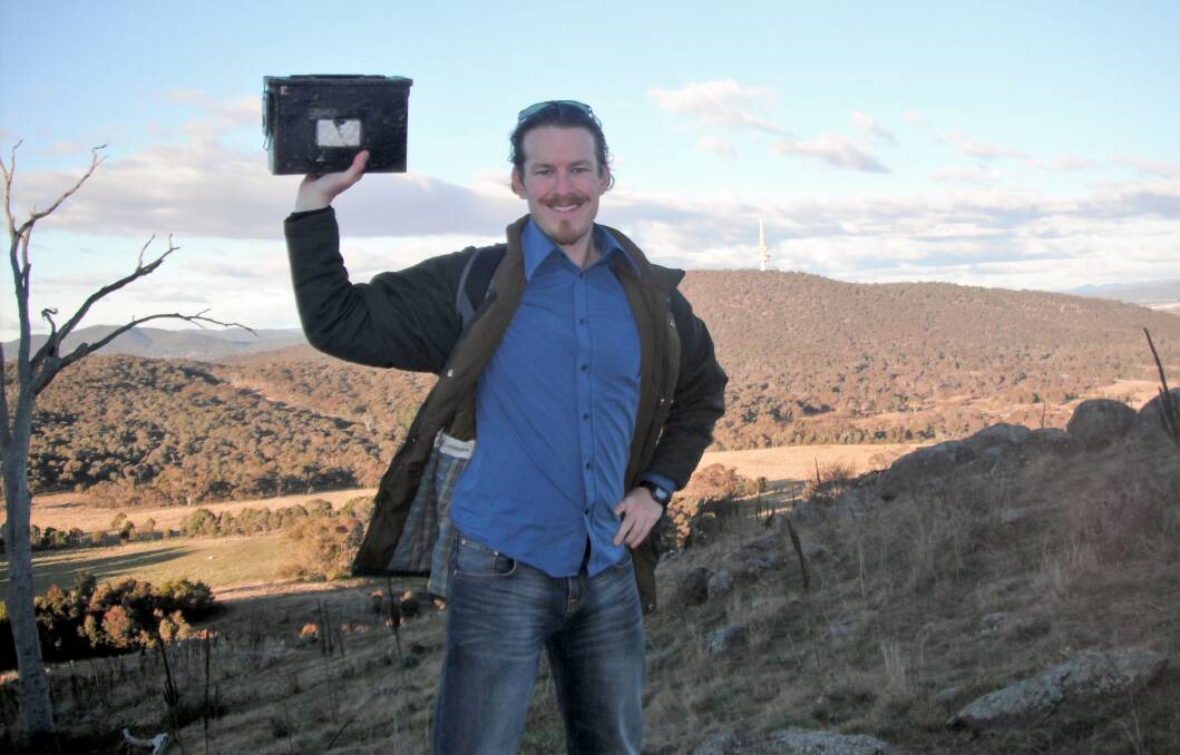 President of the Geocaching NSW Association, James Finger, with a geocache outside of the Australian Capital Territory. 