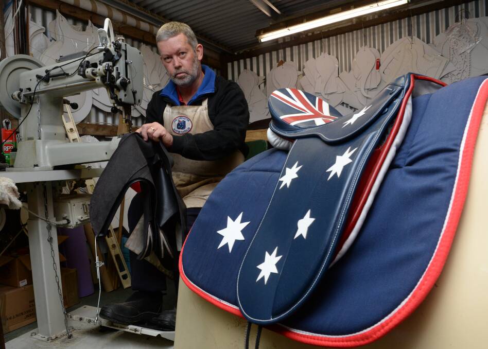 Master saddler Ian Lancaster of Redback Saddles, Binda, working on his Australian flag saddle. 