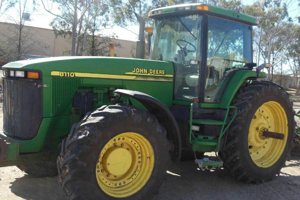 The tractor is a John Deere 8110, green and yellow in colour, like the one pictured.