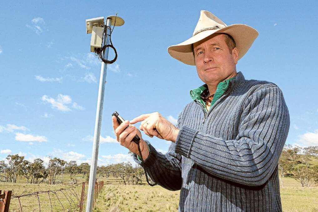 University of New England, Armidale, Professor David Lamb  beside a sensor network and using his phone to check moisture levels on the university's 'Smart Farm'. Photo: Rachael Webb