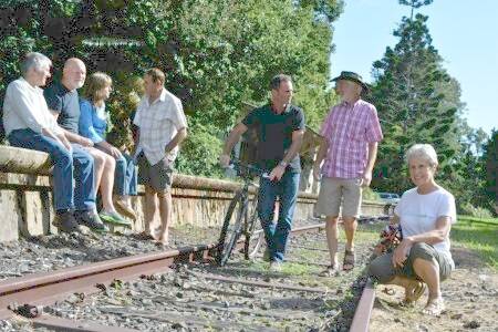 Members of the Northern Rivers Rail Trail Association Steve Martin and Geoff Meers walk the old railway line at Bangalow, watched on by fellow group members on the platform James Cowley, John Bennett, Hilary Wise and Pat Grier, with Marie Lawton at front.
