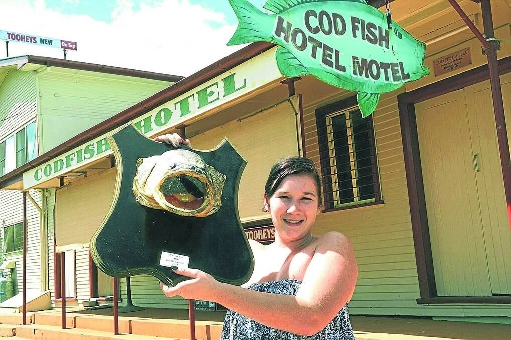 Yetman’s Codfish Hotel barmaid and cook Alyssha Mullaly with one of the pub’s many trophy Murray cod. Photo: Michael Petey