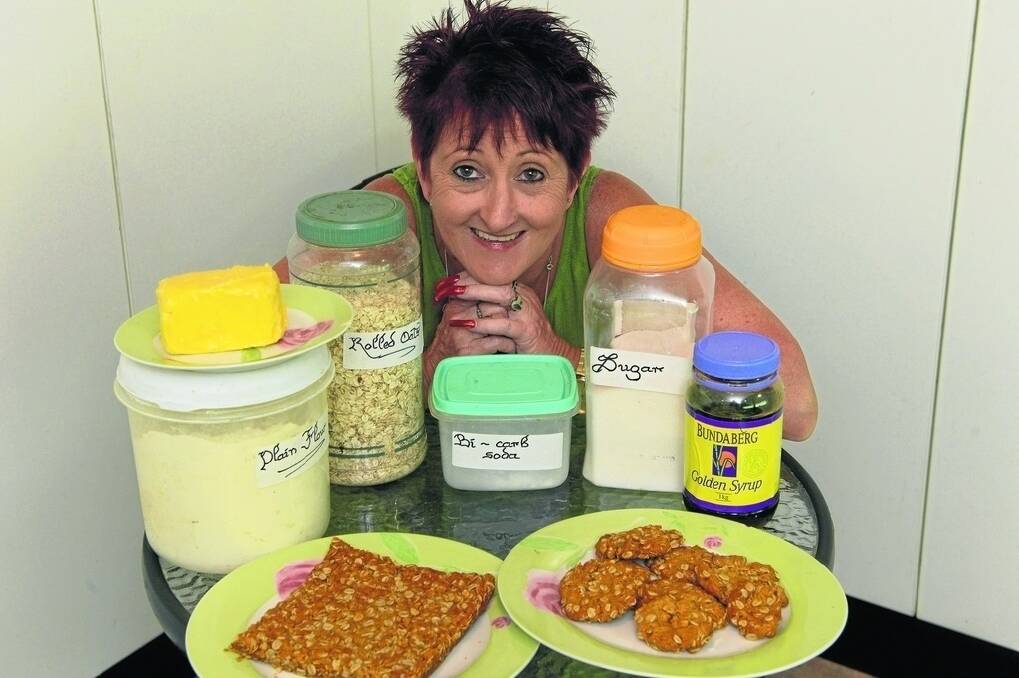 The Land Cookery Competition Committee chairwoman, Bronwyn Dunston, with the ingredients in traditional Anzacs, and an example of the original “slab” which soldiers received and the modern biscuit.