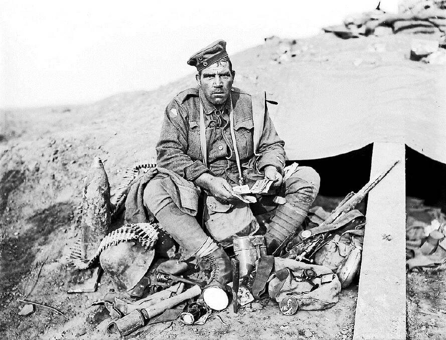 SPOILS OF WAR: Barney Hines surrounded by German souvenirs after the Battle of Polygon Wood. Photo: Australian War Memorial