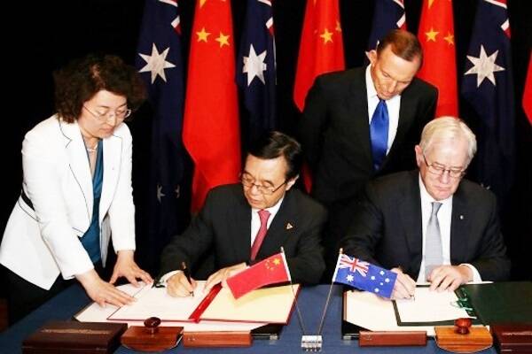 Prime Minister Tony Abbott watches as Trade Minister Andrew Robb co-signs the ChAFTA.