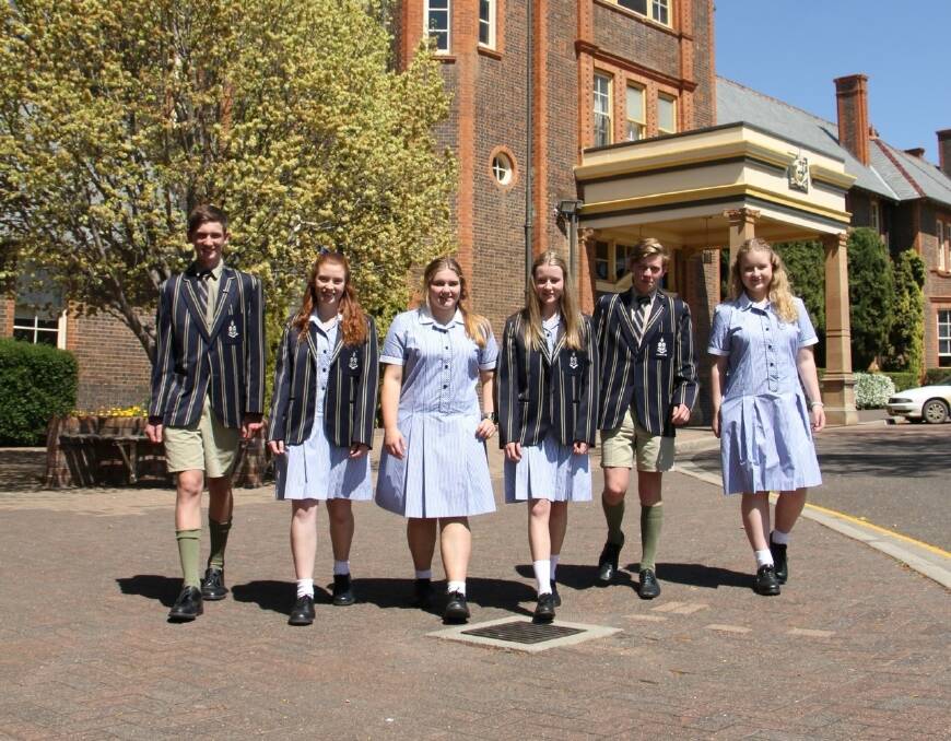 TAS deputy senior prefect Charlie Wyatt (left), and senior prefect Ben Moffatt (second from right), welcome the first secondary TAS girls who started on Tuesday. From left, Holly Tearle, Elyssa Rogers-Ellis, Maddy Dennis and Emily Blackbourne.