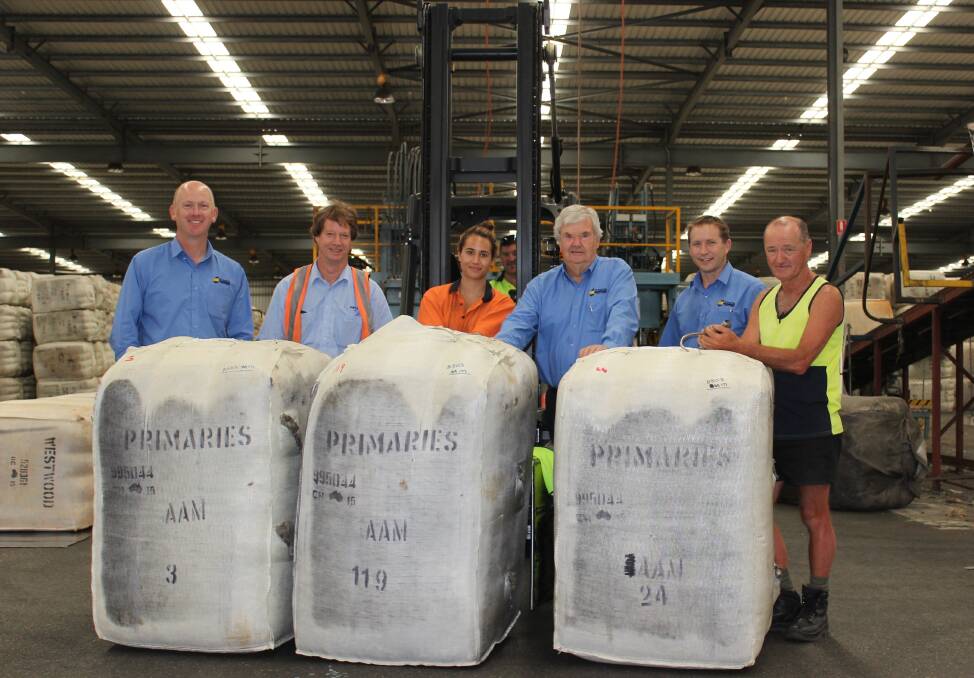 Primaries of WA general manager Andrew Lindsay, Australian Wool Testing Authority sampling officer Dennis Mudgway, Primaries wool store staff Tewenika Edmonds and Brendon Johnston on the forklift, senior auctioneer Terry Winfield, wool manager Greg Tilbrook and storeman Jim Earney with the three bales sold to raise money to help Waroona fire victims.