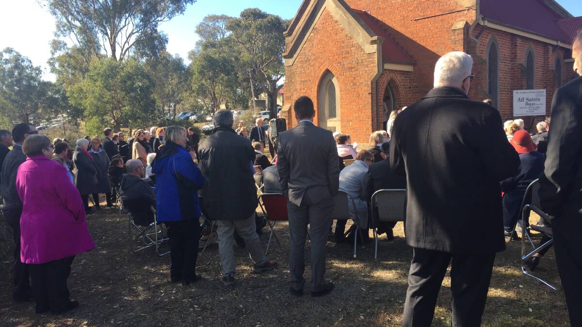 Hundreds gather: A large crowd listens to the funeral service outside of All Saints Anglican Church in Bigga.