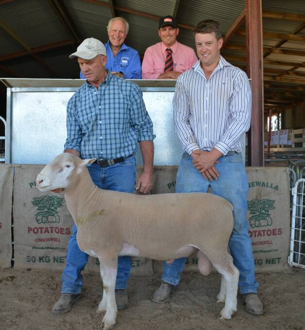 Kim Weir holding one of the $2400 rams with son, James Weir. Behind is Ian Webster, Binda, purchaser of the ram with Elders livestock agent, Daniel Tarlington. 