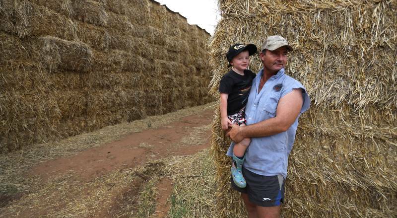 Brendan Farrell, pictured with his son Sam, has been running loads of hay to drought stricken farmers in Queensland to help feed their livestock and give them hope.