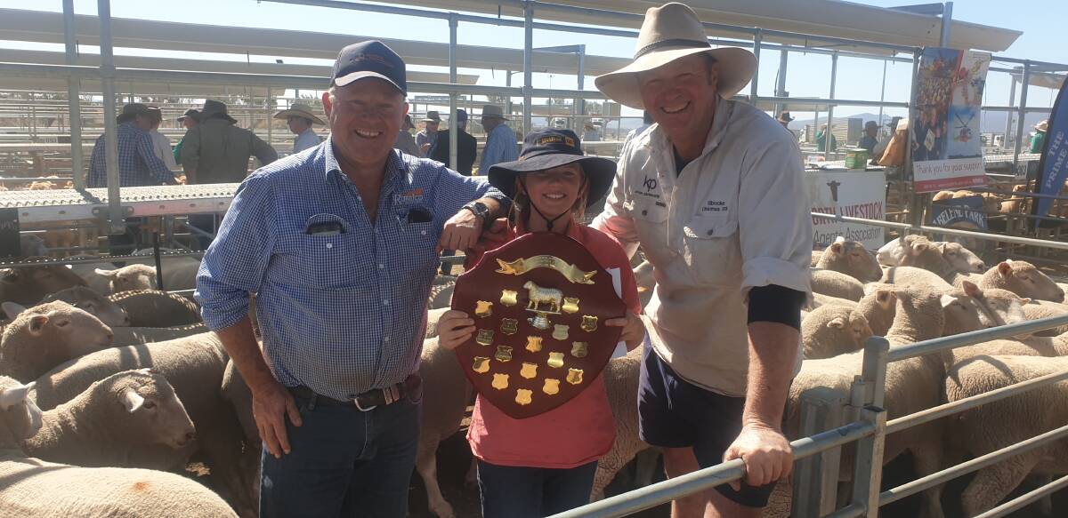 Agent Simon Burke with the winners of the JV Goodwin Memorial Shield for the champion pen of lambs, Claudia and Angus Kirton, Walcha. Photo by Michelle Mawhinney.