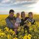 Ian and Amy Pursehouse with two of their three children, Charlotte and Henry, in a canola crop at Fairview.

