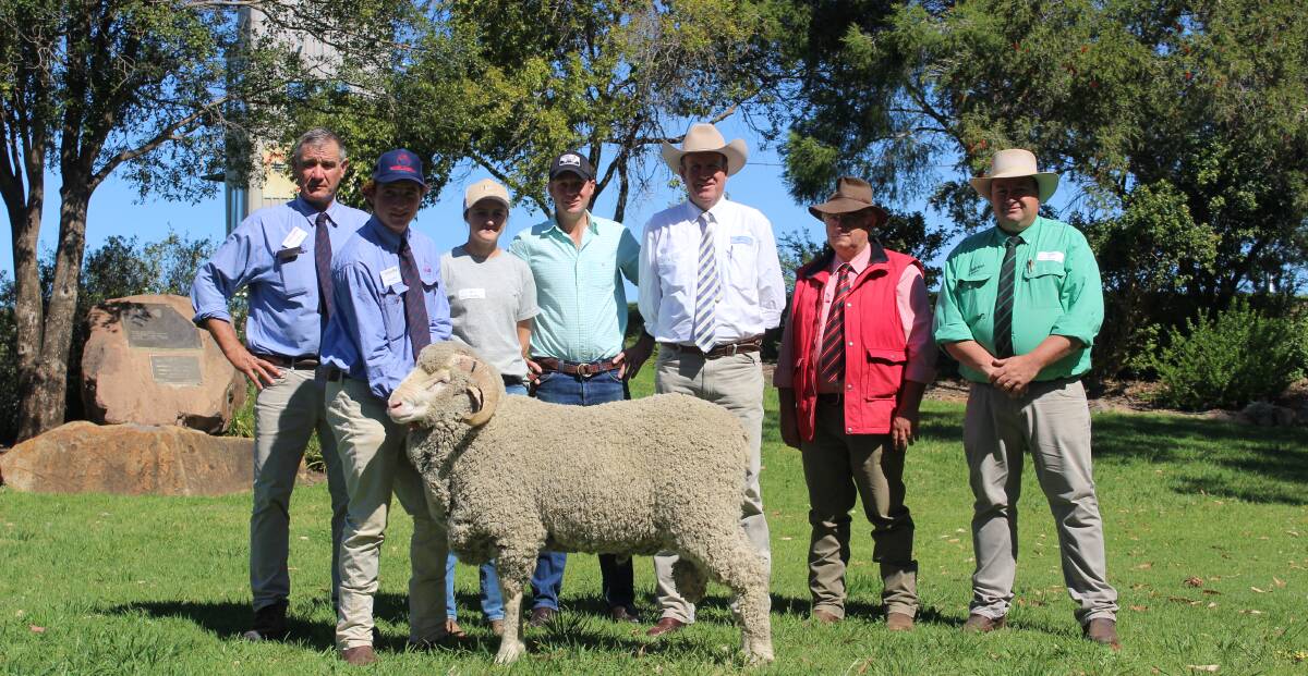 Cam Munro and Hamish Cameron, Egelabra Merino stud, Warren, with Amy Motley and Campbell Keene, HM and Co, Nyngan, auctioneer Paul Dooley, Tamworth, Scott Thrift, Elders stud stock, Dubbo, and Brad Wilson, Nutrien stud stock, Dubbo, with the $28,000 high-seller, HEK 20014.