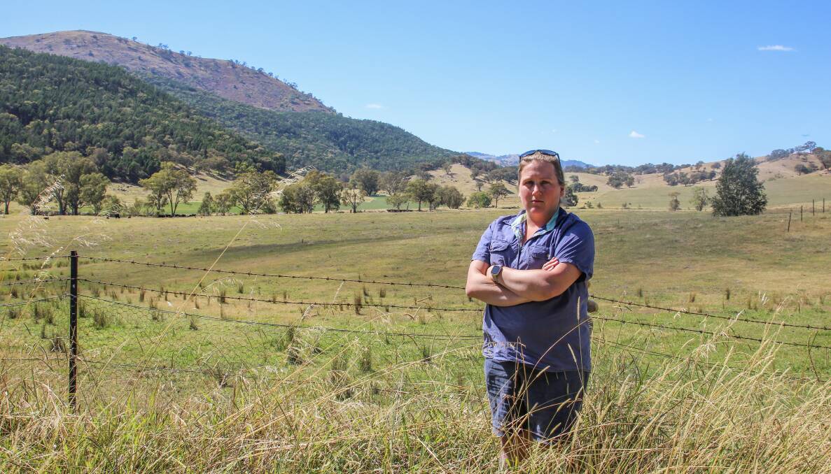 Jess Reynolds is one of the many farmers pushing for HumeLink to go underground. The ridge behind her is where the lines are proposed to go through the Reiland Angus stud at Killimicat. Photo: Alexandra Bernard