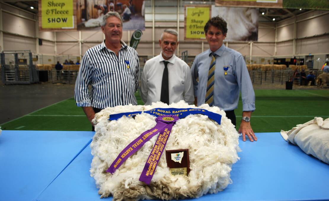 Judge Wayne Beecher, Beecher Wool Services, Cowra, steward in chief Greg Andrews, and judge Andrew Blanch, Renewable Fibres, Sydney, with the RAS/Ag Shows NSW Country Show champion fleece. Picture by Rebecca Nadge