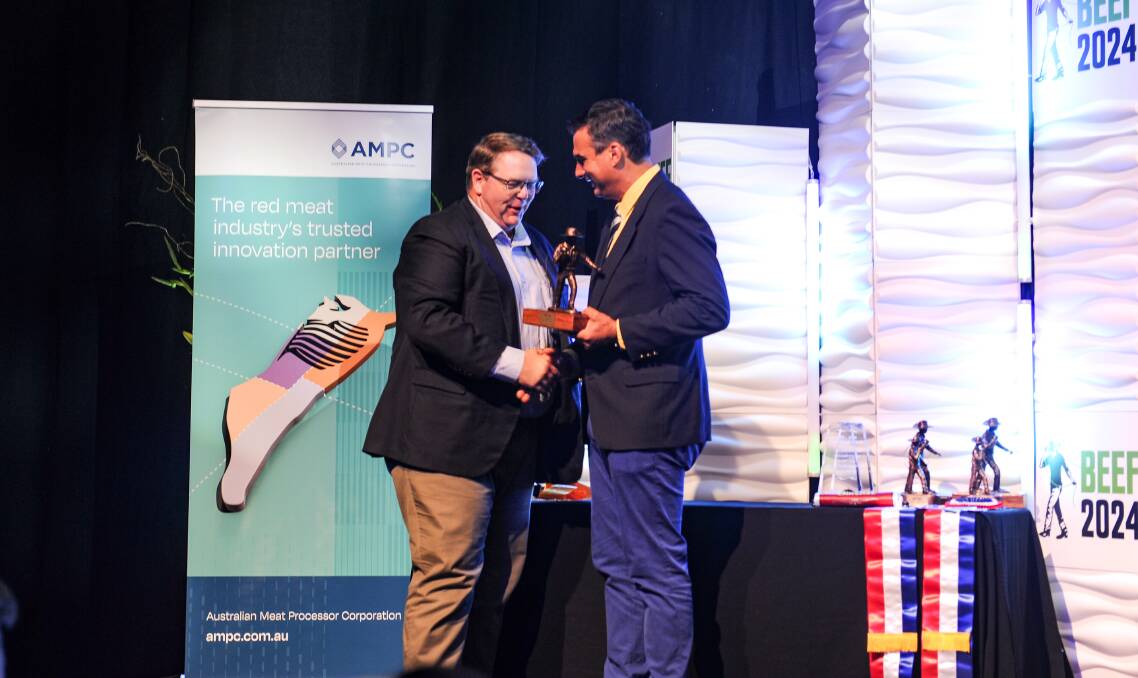 Grant Garey, Teys Australia, accepting the award on stage from UNE Associate Professor Peter McGilchrist. Picture by Ellouise Bailey 