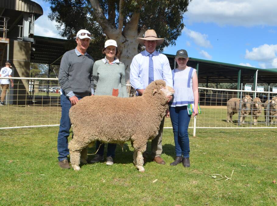 Long-term clients of Woodpark Polls, Donald and Ann Bull, Deniliquin with their $8,000 purchase paraded by Stephen and Lily Huggins. "He has good soft and crimpy wool on a bold and well structured body."
