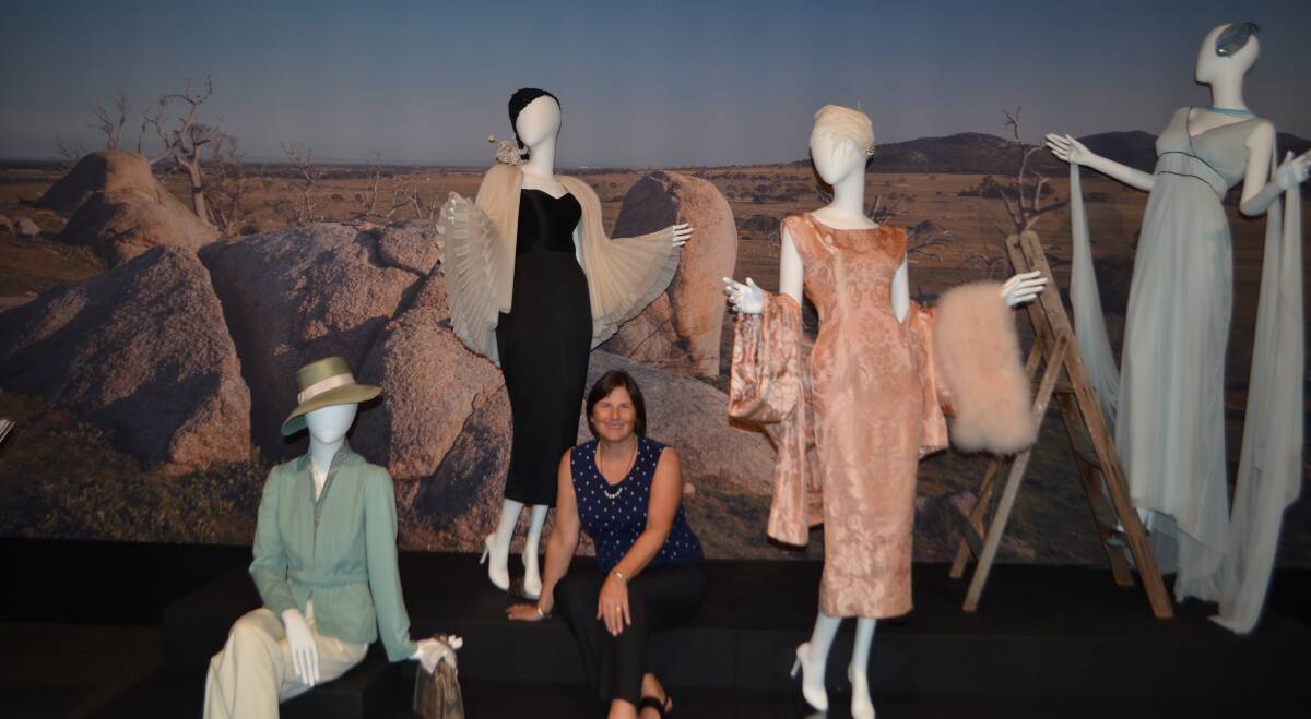 Film producer Sue Maslin sitting among some of the fantastic coustumes which featured in The Dressmaker and are on display at Albury until 31 March 2019.