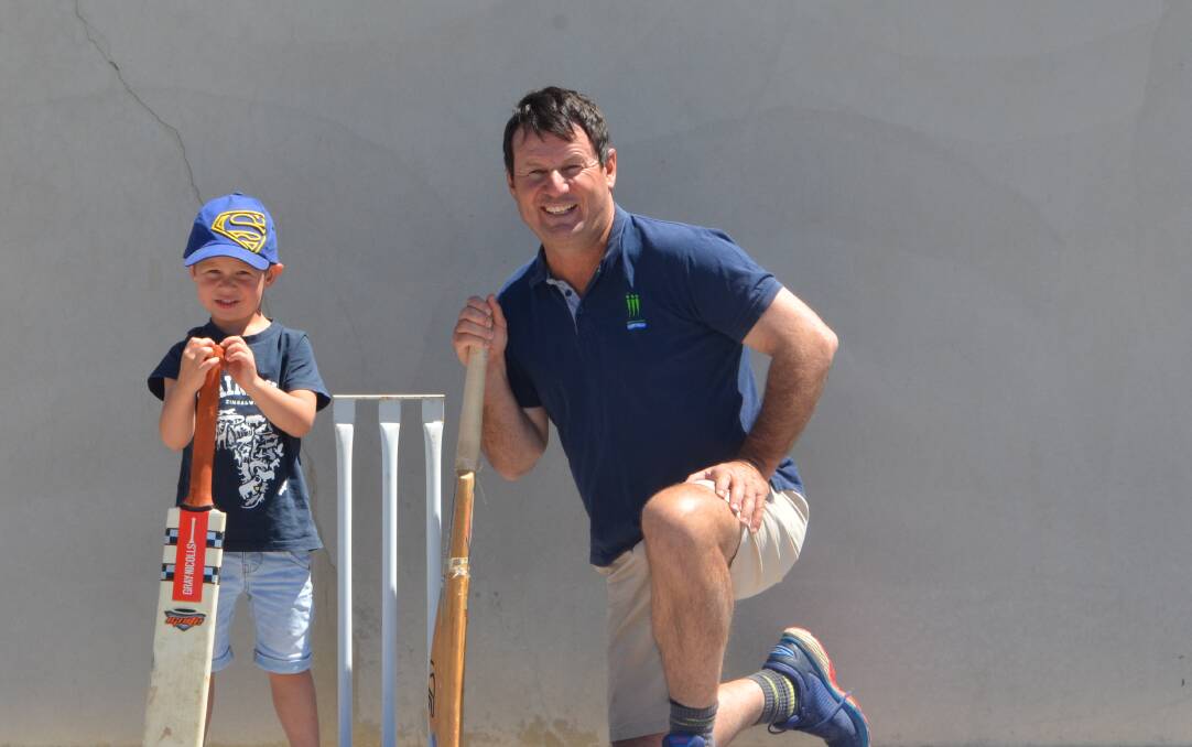 James Male with his son Daniel preparing for the National Backyard Cricket Day on the tennis court on the family farm near Yerong Creek.
