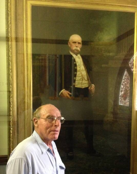 Richard Carter in the foyer of the Yanco Agricultural High School admiring the portrait of philanthropist Sir Samuel McCaughey.