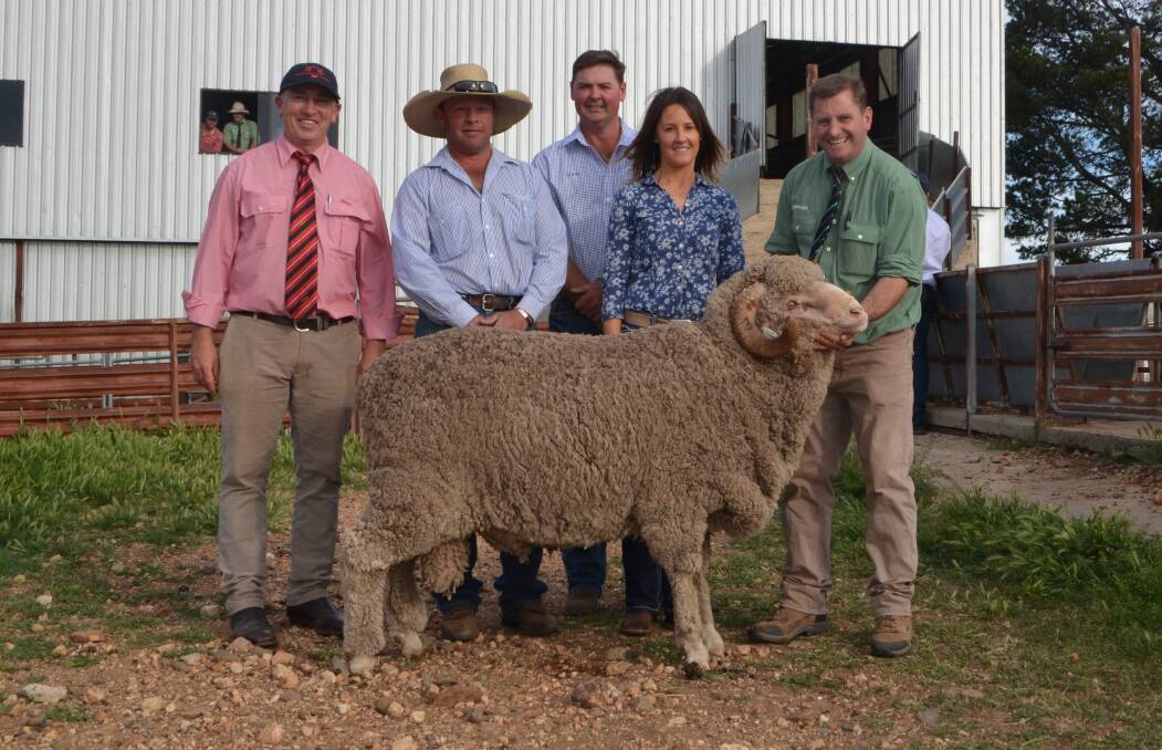 Elders agent Tim Schofield, buyers Michael Hedger of Snowy Plain Merinos, with vendors Mark and Jodie Pendergast, Cottage Park Merinos, and the top priced ram paraded by Rick Power, Landmark stud sheep consultant.