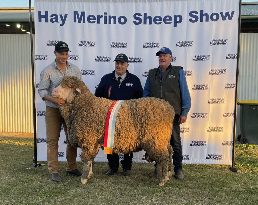Bill Lamb Perpetual Trophy for Supreme Champion ram of ewe at 2022 show - Tim Dalla, Collinsville, Burra, SA, sashed by Ian Lugsdin, show committee president, with Tony Brooks, Brooks Merino Services, Burra, SA.