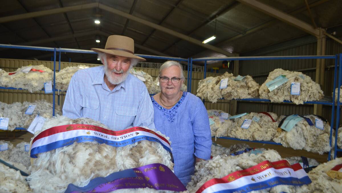 Winston and Sue McDonald, Royalla Merinos, Wallendbeen, with their champion fleece grown by a show ewe sired by Roseville Park 14. The couple also exhibited the reserve champion fleece.