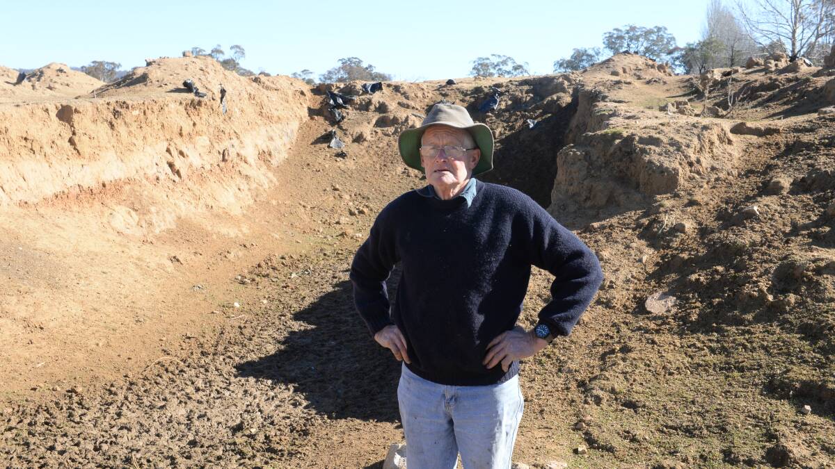 Richard Webb standing beside a silage pit with 70 lucerne bales buried (been in there for two years) which will be opened in a couple of weeks to one months time. This will last til the end of winter. Pits put in around 1984/85